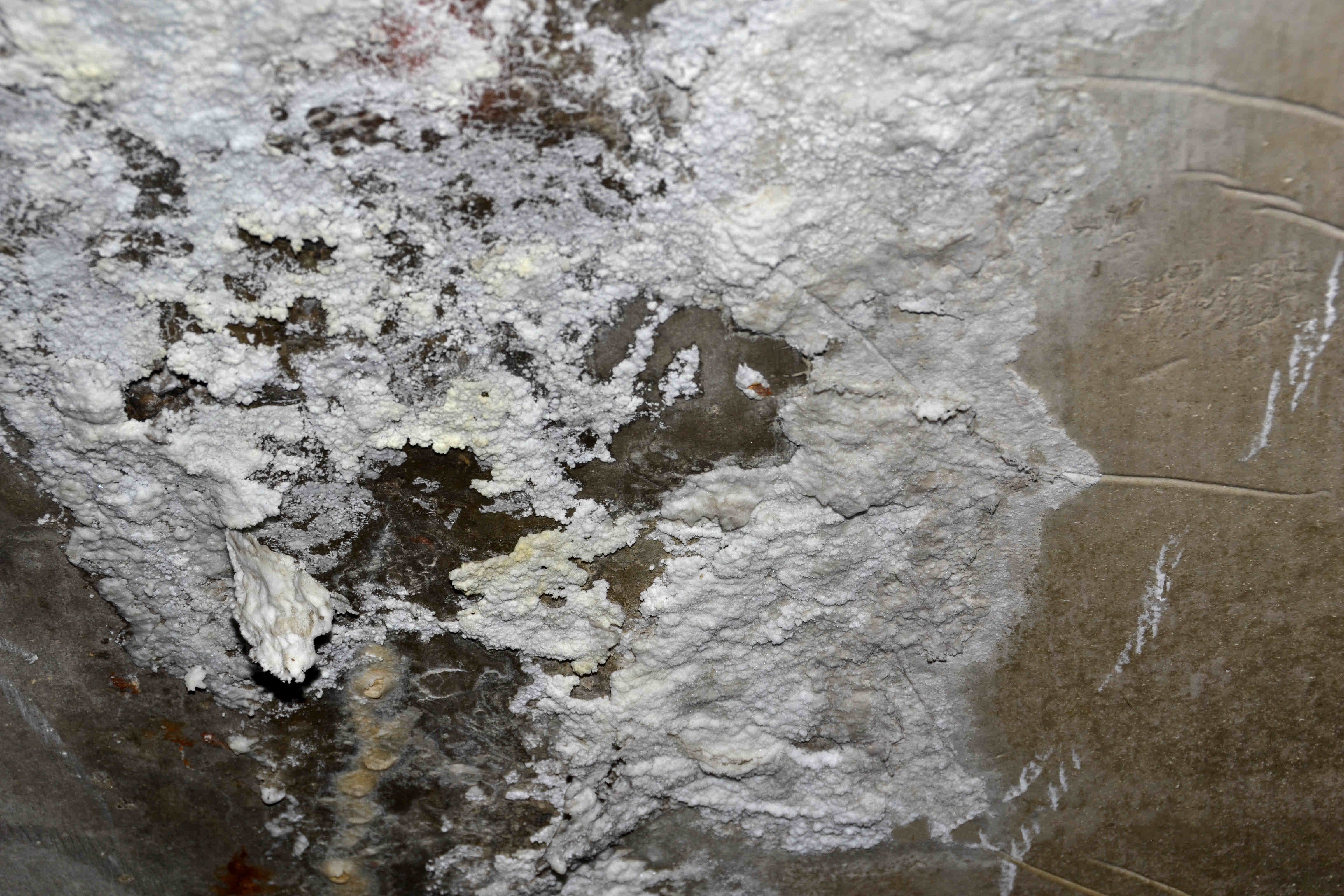 White, powdery efflorescence on a fieldstone foundation loading=